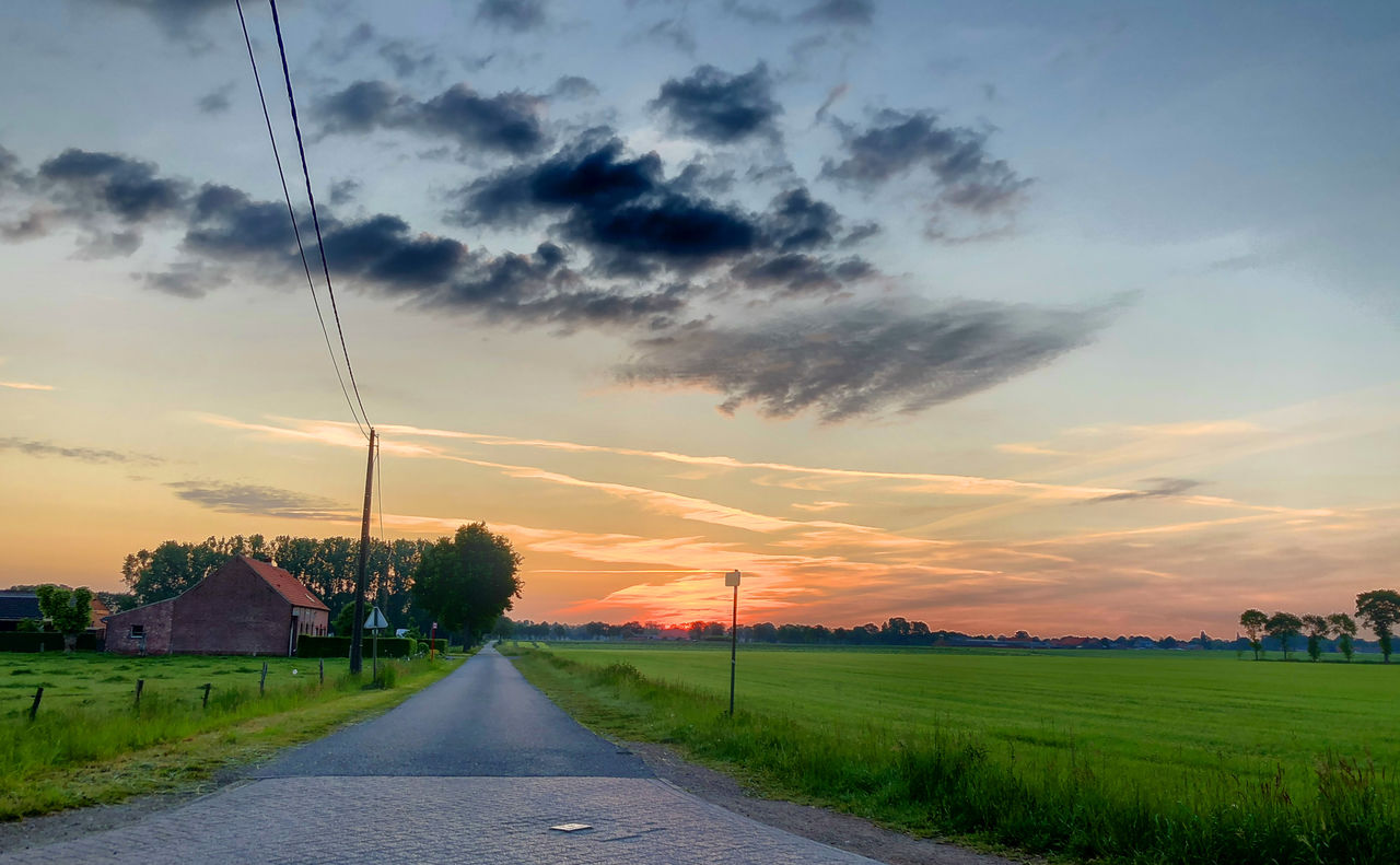 sky, cloud, landscape, sunset, environment, horizon, road, nature, rural scene, plant, beauty in nature, field, transportation, land, agriculture, scenics - nature, rural area, grass, dusk, sunlight, no people, evening, dramatic sky, tranquility, architecture, outdoors, city, the way forward, sun, farm, diminishing perspective, blue, vanishing point, cloudscape, plain, tranquil scene, twilight, crop, tree, street, idyllic, travel, summer, multi colored, moody sky, built structure, orange color