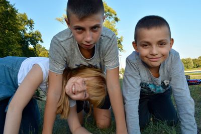 Portrait of siblings kneeling at park