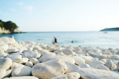 Surface level of pebbles on beach against sky