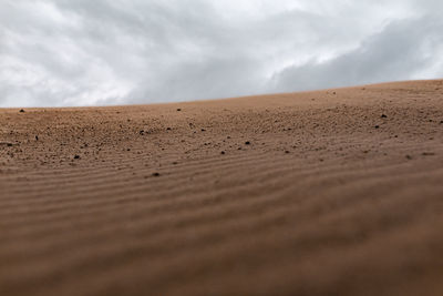 Surface level of sand dunes against sky