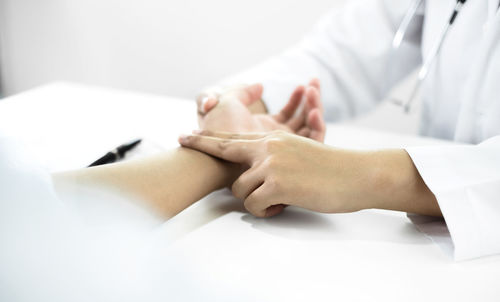 Midsection of doctor examining patient at clinic
