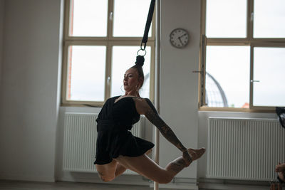 Side view of woman exercising at home