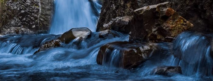 Scenic view of waterfall against sky at night