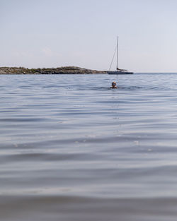 Sailboats sailing in sea against sky