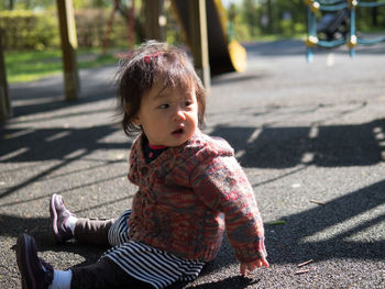 Close-up of baby girl sitting at playground
