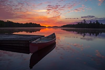 Fiery sunset and red canoe on a lake