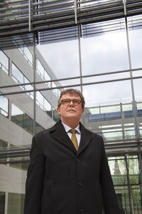 Low angle view of man wearing mask standing against ceiling