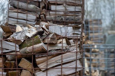 Stack of logs against fence