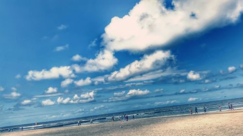 Scenic view of beach against cloudy sky