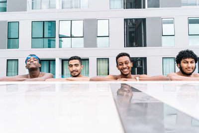 Group of young people leaning on the edge of a pool