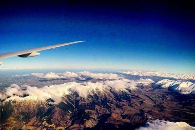 Cropped image of airplane flying over mountains