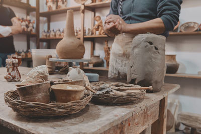 Man molding clay to make ceramics with his hands, artisan working in his workshop, selective focus