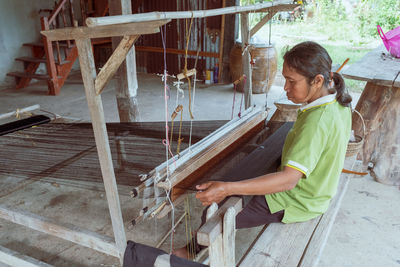 Side view of a girl sitting on wood