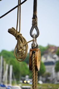 Close-up of rope tied to wooden post against sky