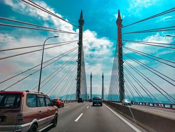 View of suspension bridge against cloudy sky