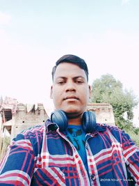 Portrait of young man standing against sky