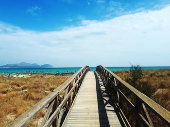Panoramic view of wooden walkway leading towards sea against sky