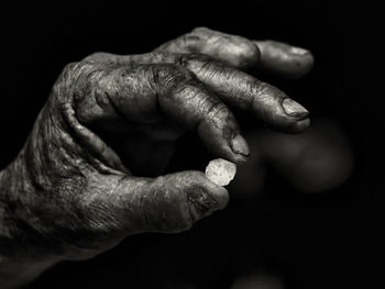 Close-up of man hand against black background