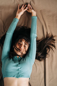 High angle view of woman lying down on bed