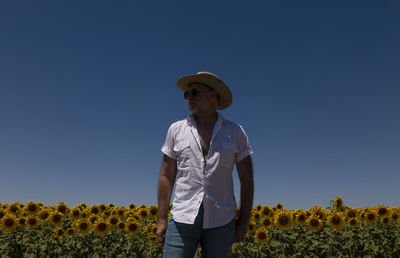 Adult man in cowboy hat and sunglasses in sunflowers fields. castilla y leon, spain