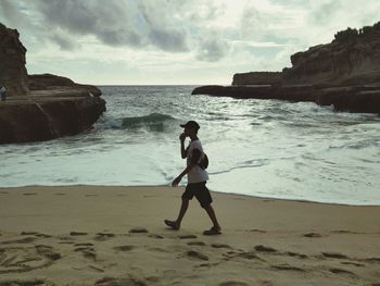 Full length of young woman standing on beach
