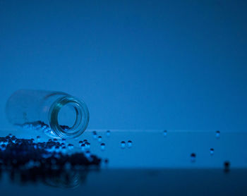 Close-up of water drops on glass against blue background