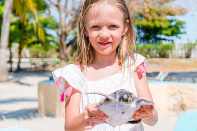 Portrait of cute girl holding turtle