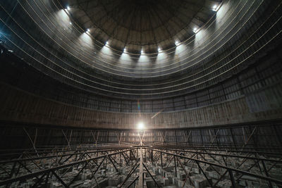 Interior of round dark room with dome and dim lamp inside derelict industrial facility