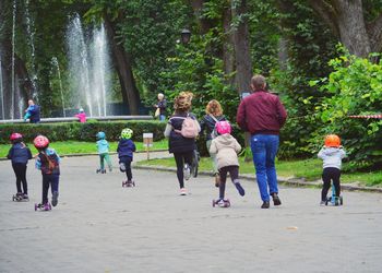 Rear view of people walking on plants