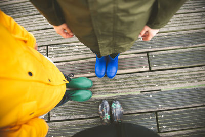 Low section of girl standing with brother on boardwalk