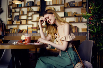 Smiling young woman sitting in cafe