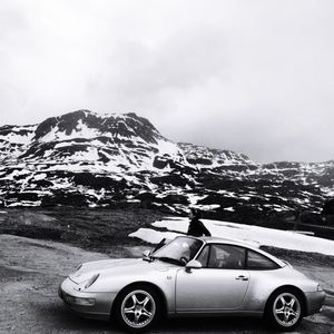 Car on snowcapped mountain against sky