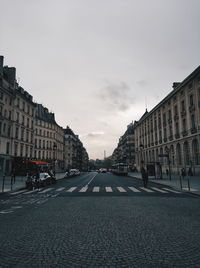 Street amidst buildings against sky in city