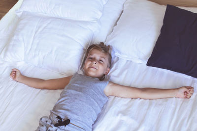 High angle view of boy lying on bed at home
