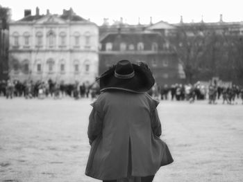 Rear view of woman standing in city during winter