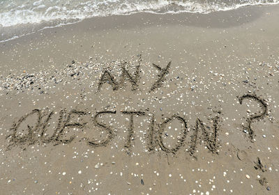 High angle view of text on sand at beach