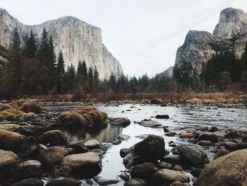 Scenic view of rocks by lake against sky