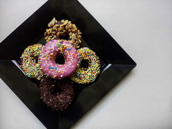 Multi colored donuts in tray on table