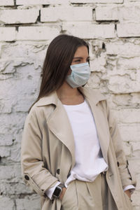 Full length of woman standing against wall