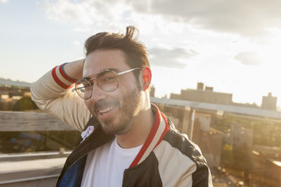 Portrait of young man standing against sky