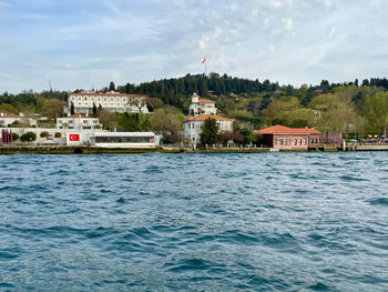 Buildings by sea against sky