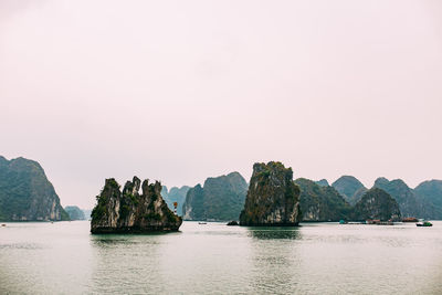 Scenic view of rocks in sea against clear sky