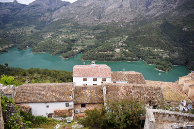 High angle view of buildings and sea against mountains