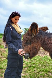 Side view of man with horse on field