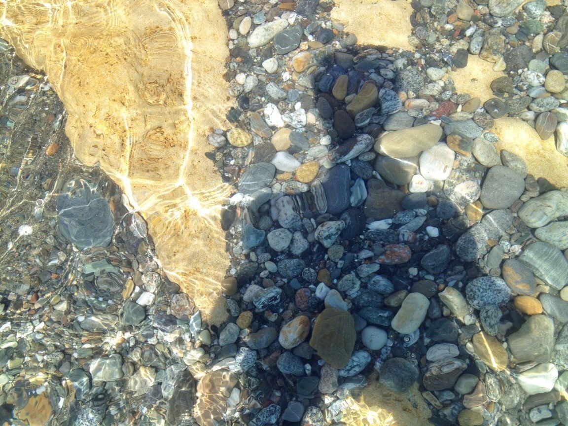 stone - object, rock - object, high angle view, pebble, abundance, backgrounds, textured, large group of objects, full frame, sunlight, water, nature, day, stone, pattern, outdoors, no people, tranquility, stack, firewood