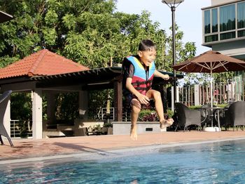 Full length of boy jumping in swimming pool