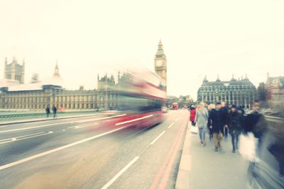 Blurred motion of people and bus on westminster bridge