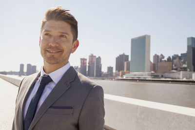 Portrait of a young businessman on a rooftop overlooking the city