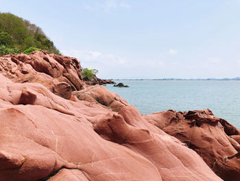 Rock formations by sea against sky