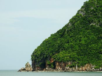 Scenic view of sea by cliff against sky